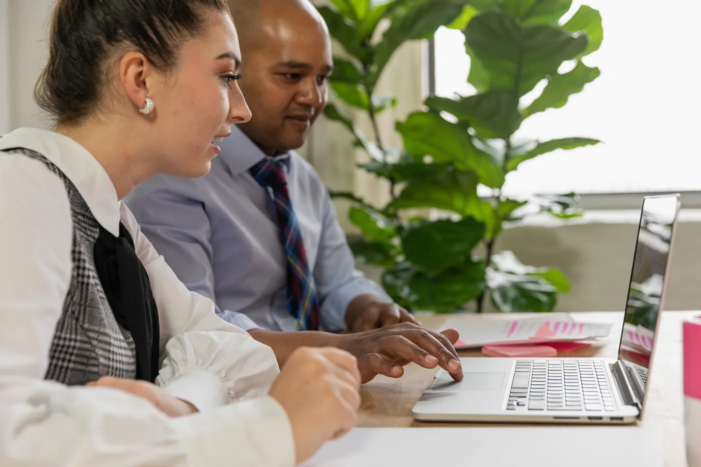 Two professionals learning and collaborating together over a laptop